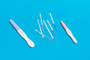 Colored Pregnancy test on colored background, top view with copy space